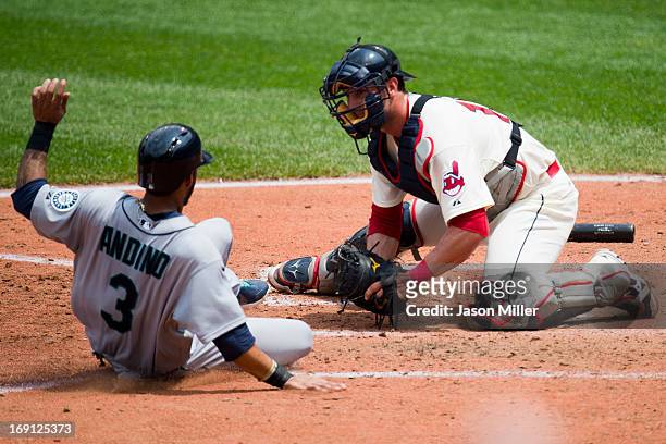 Robert Andino of the Seattle Mariners is out at home as catcher Yan Gomes of the Cleveland Indians makes the tag during the fourth inning at...
