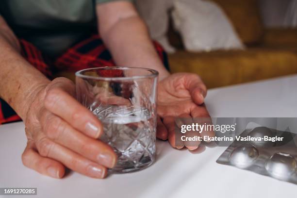 senior woman taking pills - prendre des cachets photos et images de collection
