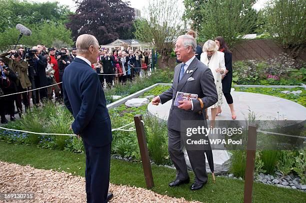 Prince Charles, Prince of Wales shares a laugh with his father Prince Philip, Duke of Edinburgh as he visits the Sentebale Forget-me-not garden at...