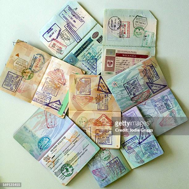 stack of open passports with date stamps and visas - australia passport ストックフォトと��画像