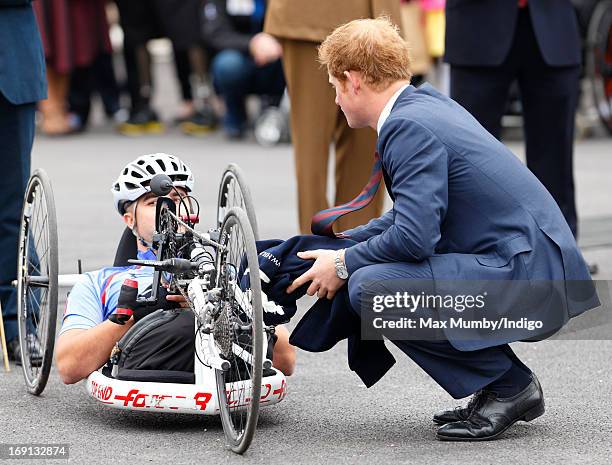 Prince Harry talks with injured US veteran Corporal Charlie Lemon who is taking part in the 2013 Hero Ride on a recumbent hand bike as he and Prince...