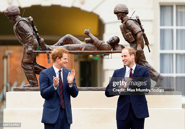 Prince Harry and Prince William, Duke of Cambridge stand in front of the Help for Heroes statue as they attend the opening of the new Help for Heroes...