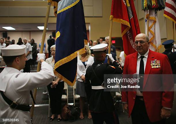 Marine Gunnery Sergeant Louis Slagle stands as a military honor guard walks past during a ceremony to remember and honor those who have died in...