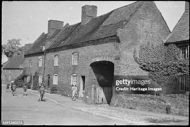 Home Farm, Church Street, Bunny, Rushcliffe, Nottinghamshire, June 1947. The carriage entrance and adjoining cottages at Home Farm showing the gable...