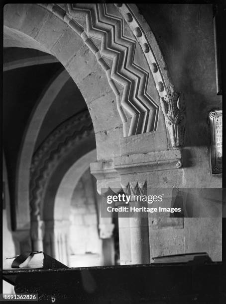 St John's Church, Elkstone, Cotswold, Gloucestershire, 1920-1940. A detail of a dragon head and chevrons carved on the chancel arch of St John's...