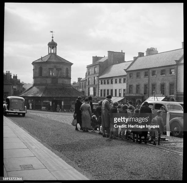 Market Place, Barnard Castle, County Durham, 1936. Looking south along the Market Place towards the Market Cross in Barnard Castle, showing a group...