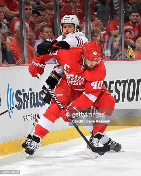 Henrik Zetterberg of the Detroit Red Wings handles the puck as Duncan Keith of the Chicago Blackhawks tries to defend him during Game Three of the...