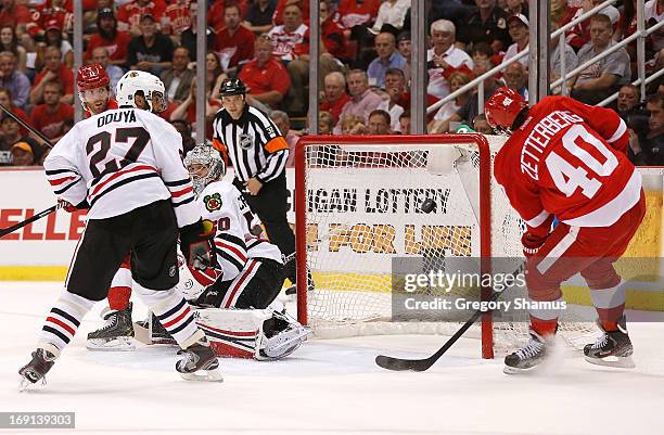 Henrik Zetterberg of the Detroit Red Wings can't get the puck into the net during the first period next to Corey Crawford and Johnny Oduya of the...