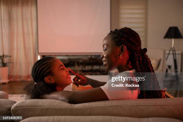 happy mother and daughter are watching a movie in their home theater - film screening room stock pictures, royalty-free photos & images