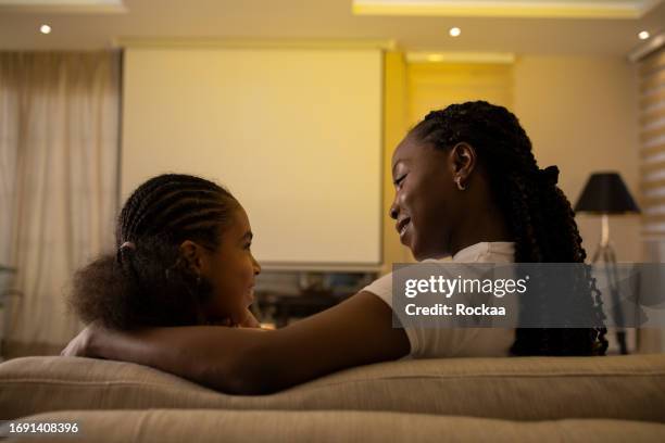 mother and daughter are watching a movie - film screening room stock pictures, royalty-free photos & images