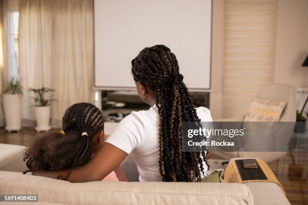 mother and daughter are watching a movie - film screening room stock pictures, royalty-free photos & images