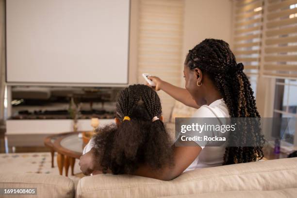 happy mother and daughter are watching a movie in their home theater - film screening room stock pictures, royalty-free photos & images