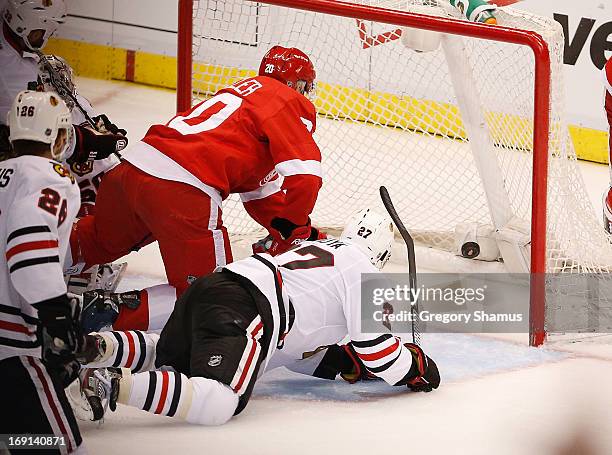 Drew Miller of the Detroit Red Wings beats Johnny Oduya of the Chicago Blackhawks to the puck to score a second period goal in Game Three of the...