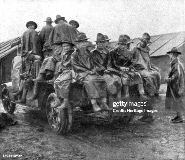 Installation en France de L'Avant-Garde Americaine; Un groupe en manteau de pluie amené en camion', 1917. First World War: the American advance guard...