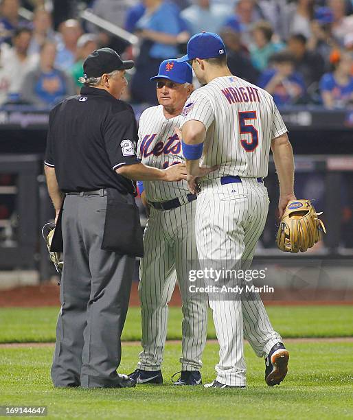 Manager Terry Collins and third baseman David Wright of the New York Mets have a discussion with home plate umpire Tom Hallion during the game...