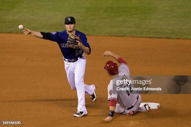 Second baseman Josh Rutledge of the Colorado Rockies is unable to complete the double play as Eric Chavez of the Arizona Diamondbacks slides in to...
