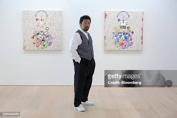 Takashi Murakami, a Japanese contemporary artist, poses for a photograph in front of his paintings on exhibit at the Galerie Perrotin in Hong Kong,...