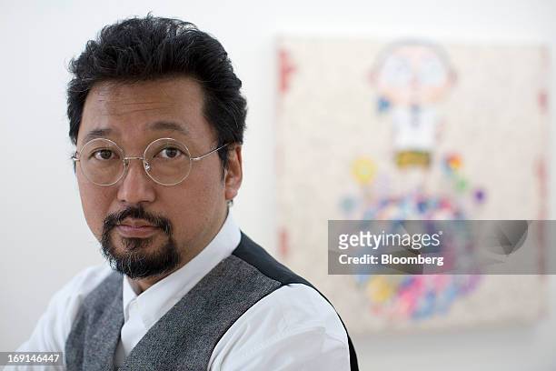 Takashi Murakami, a Japanese contemporary artist, poses for a photograph in front of one of his paintings on exhibit at the Galerie Perrotin in Hong...