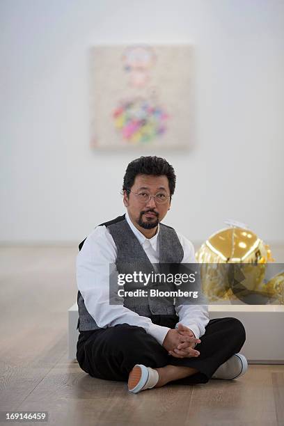 Takashi Murakami, a Japanese contemporary artist, sits for a photograph next to his artwork at the Galerie Perrotin in Hong Kong, China, on Monday,...
