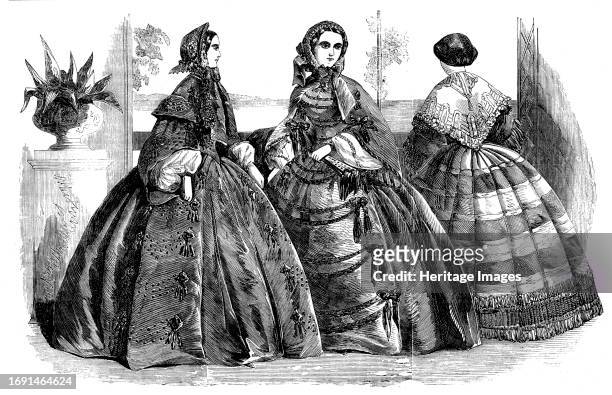 Fashions for July, 1858. 'Fig. 1: Dress of green silk, with quilles or sides trimmings of black passementerie...The corsage, which is pointed at the...
