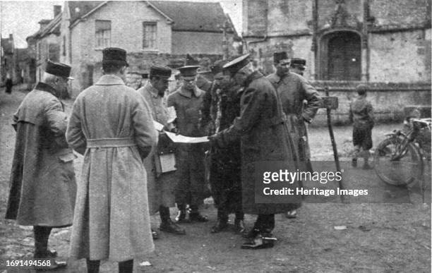 Amalgame franco-americain"; le general Pershing examinant la carte au milieu d'un groupe d'officiers americains et francais; a sa droite, le general...