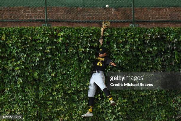 Jack Suwinski of the Pittsburgh Pirates can't catch a home run hit by Dansby Swanson of the Chicago Cubs during the first inning at Wrigley Field on...