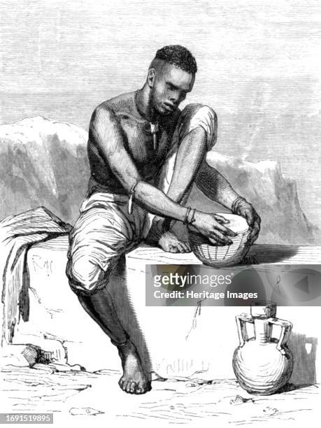 Native of the Dinka tribe,white Nile, mending his drum; The Nile Valley above Khartum', 1875.From, 'Illustrated Travels' by H.W. Bates. [Cassell,...