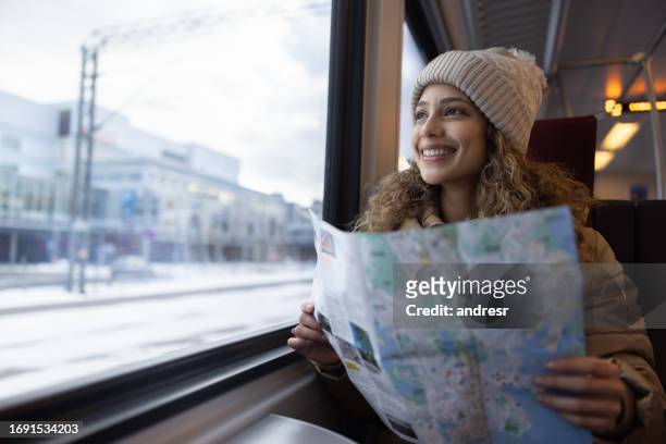 happy tourist traveling by train and holding a map - finland map stock pictures, royalty-free photos & images