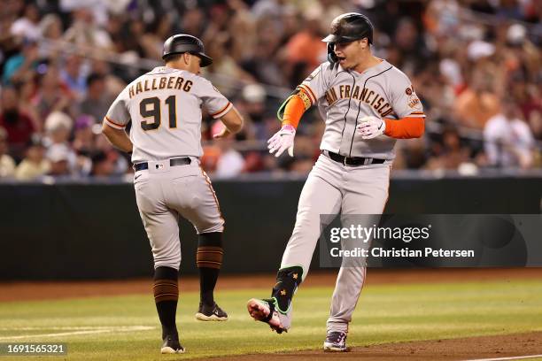 Joc Pederson of the San Francisco Giants celebrates with third-base Mark Hallberg after hitting a solo home run against the Arizona Diamondbacks...