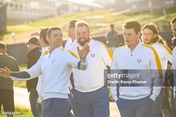 Team Europe players Rory McIlroy and Shane Lowry smile and wave to fans during a team photo call prior to the 2023 Ryder Cup at Marco Simone Golf...