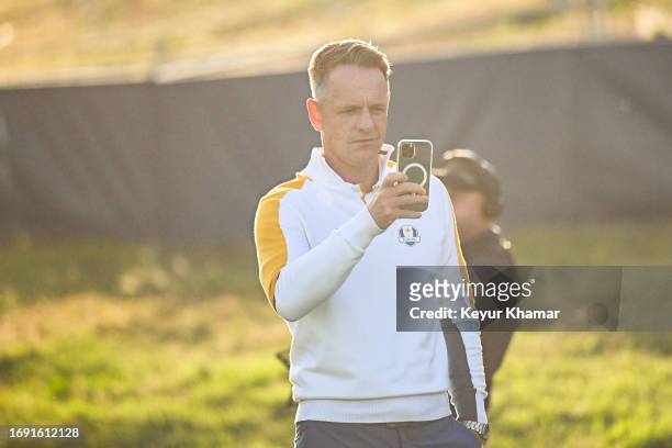 Team Europe Captain Luke Donald uses a mobile phone to take pictures on the first tee during a team photo call prior to the 2023 Ryder Cup at Marco...