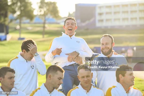 Team Europe players Rory McIlroy and Tyrrell Hatton smile as McIlroy is lifted by teammate Shane Lowry during a team photo call prior to the 2023...