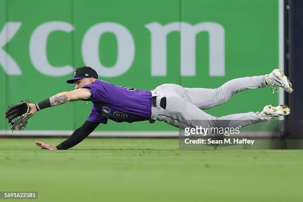 Brenton Doyle of the Colorado Rockies dives to make the catch of a fly ball hit by Jurickson Profar of the San Diego Padres during the sixth inning...