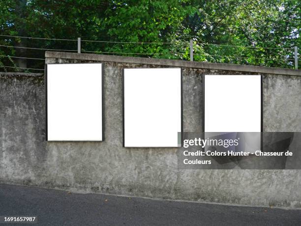 three rectangular, empty, white billboards on the grey concrete perimeter wall of a park in lausanne, vaud canton, switzerland - three ways stock pictures, royalty-free photos & images