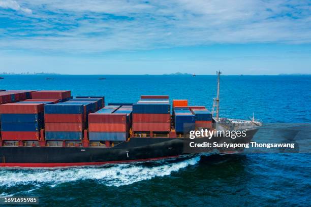 aerial side view container cargo ship full speed with beautiful wave pattern carrier container on the sea for business logistics, import export, shipping or freight transportation. - truck side view stock pictures, royalty-free photos & images