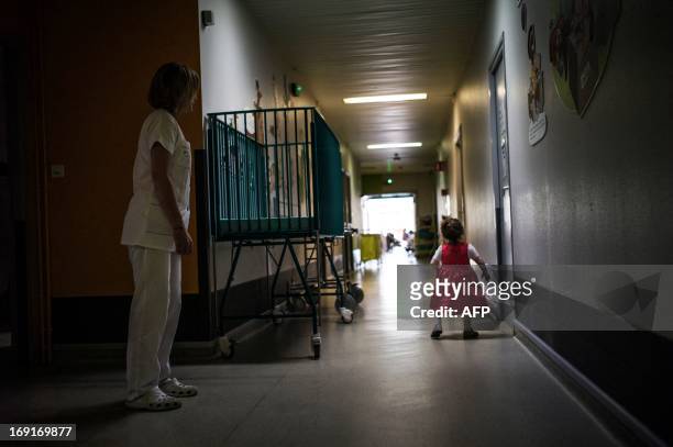 Child walks in a corridor with an employee at the pediatric centre "La Maisonee", specialised in care for disabled children living under ventilatory...