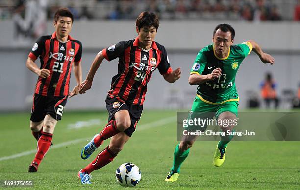 Yun Il-Lok of FC Seoul competes for the ball with Xu Yunlong of Beijing Go'an during the AFC Champions League round of 16 match between FC Seoul and...