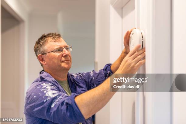 man installing a smoke detector - smoke alarm installation stock pictures, royalty-free photos & images