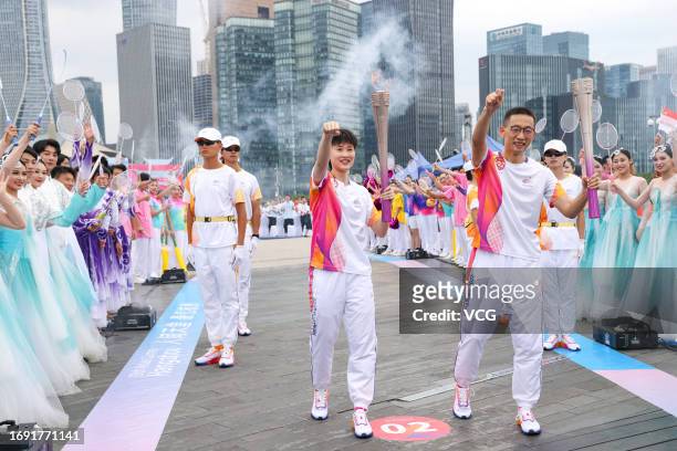 Chinese badminton player Chen Yufei and Westlake University president Shi Yigong pose for a photo with torches during the torch relay of the 19th...