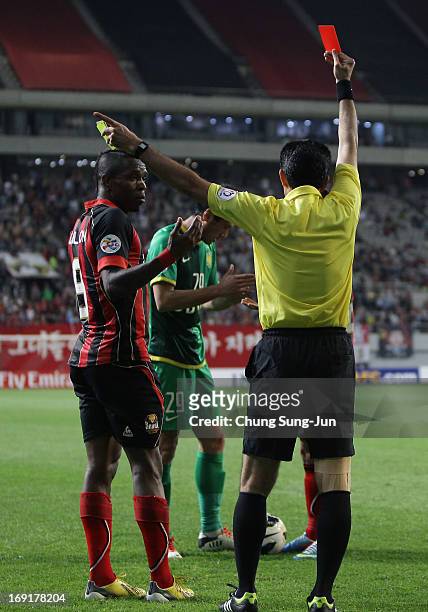 Adilson Dos Santos of FC Seoul receives a red card from referee Torki Mohsen during the AFC Champions League round of 16 match between FC Seoul and...