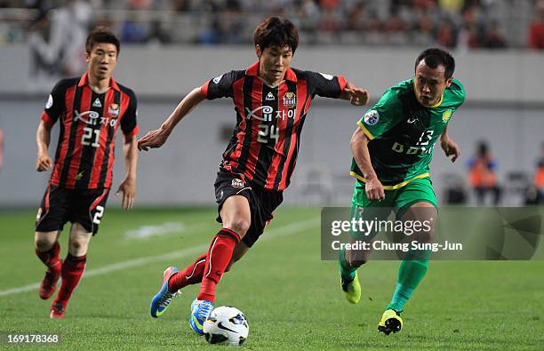 Yun Il-Lok of FC Seoul competes for the ball with Xu Yunlong of Beijing Go'an during the AFC Champions League round of 16 match between FC Seoul and...