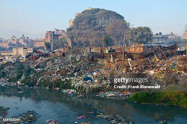 People live in shacks on the garbage dump at Bhagmati River in the middle of the city. The garbage collected off the streets of the capital city is...