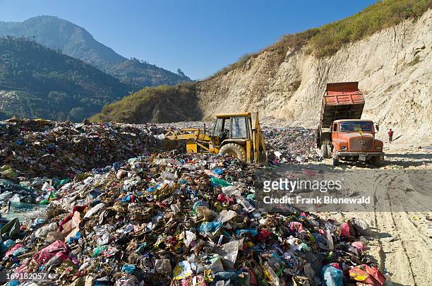 An orange truck delivering garbage from Kathmandu at Aletar garbage dump. The garbage collected off the streets of the capital city is mostly sorted...