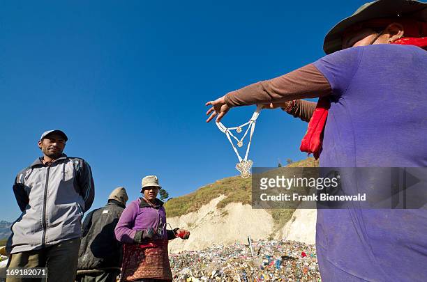 Woman sorting out garbage at the Aletar garbage dump, finds a piece of cheap jewellery. The garbage collected off the streets of the capital city is...