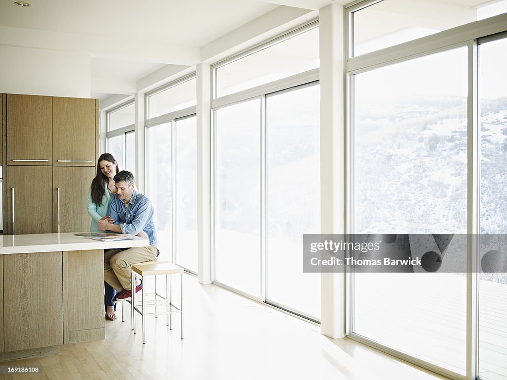 Couple in home smiling looking at digital tablet