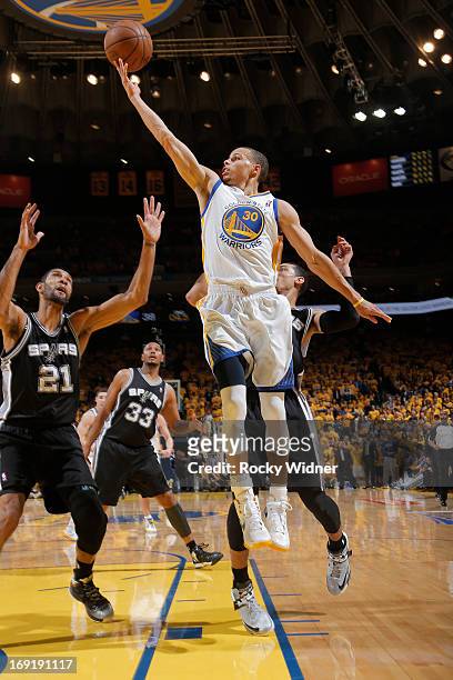 Stephen Curry of the Golden State Warriors puts up a shot against Tim Duncan of the San Antonio Spurs in Game Six of the Western Conference...