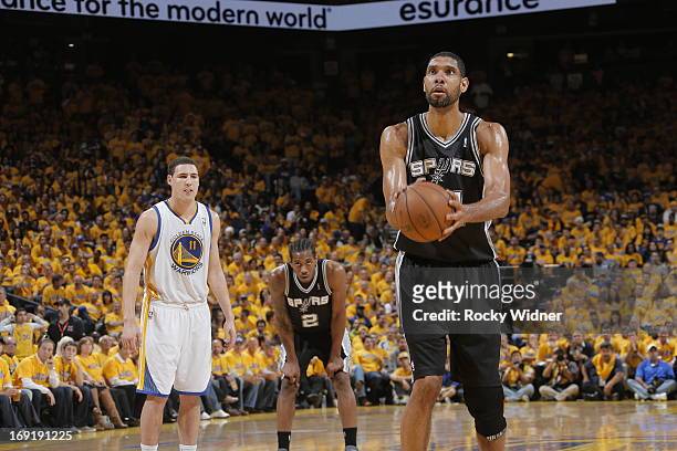 Klay Thompson of the Golden State Warriors and Kawhi Leonard of the San Antonio Spurs look on as Tim Duncan of the San Antonio Spurs attempts a free...