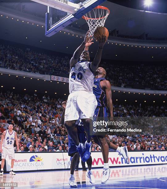 Shawn Kemp of the Orlando Magic covered from behind by Bryon Russell of the Washington Wizards goes up for the shot during the game at TD Waterhouse...