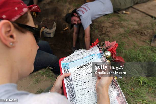 Forensic anthropologist Krista Latham from the University of Indianapolis records evidence as her team exhumes the remains of unidentified immigrants...