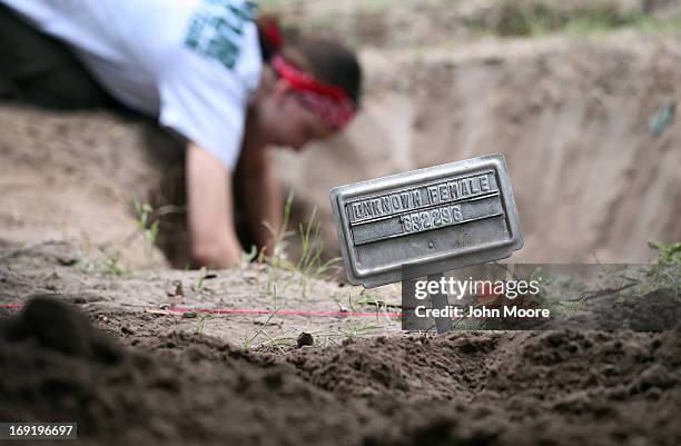 Forensic anthropology team member Audrey Murchland from Baylor University unearths the remains of unidentified immigrants from a cemetery on May 21,...